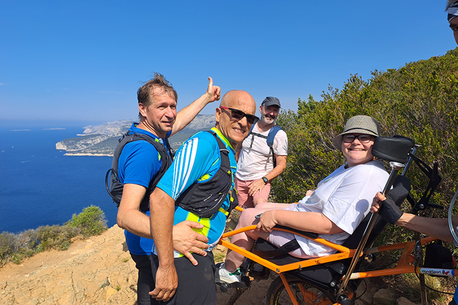 Une visiteuse sur une joêlette apprécie un panorama sur les Calanques